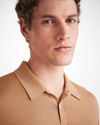 An image of a man from his shoulders to the top of his hair line showing off the camel color short sleeve polo shirt with a ribbed collar and two mother of pearl buttons 