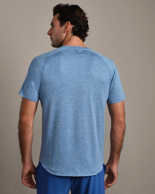 Back view of a heather blue performance T-shirt with short sleeves, crew neckline, and athletic fit, paired with blue athletic shorts against a neutral background.