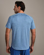 Back view of a heather blue performance T-shirt with short sleeves, crew neckline, and athletic fit, paired with blue athletic shorts against a neutral background.