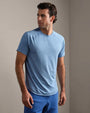 Person wearing a heather blue performance T-shirt with short sleeves and bright blue athletic shorts in a neutral indoor setting.