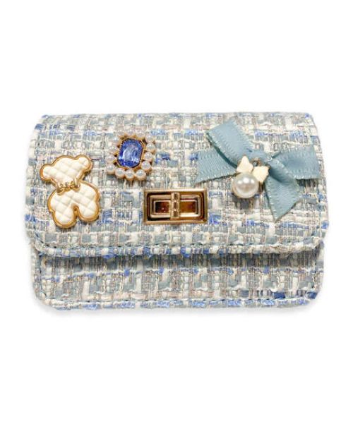 Blue tweed little girls purse with a quilted ivory and gold bear charm, blue jewel with little pearls around charm, gold twist clasp, and a small blue bow with a pearl dangling off the middle of the bow on the front flap of the purse. 
