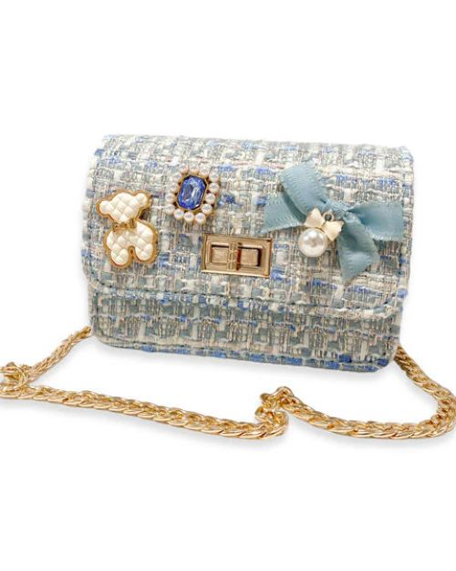 Blue tweed and gold chain little girls purse with a quilted blue and gold bear charm, blue jewel with little pearls around charm, gold twist clasp, and a small blue bow with a pearl dangling off the middle of the bow on the front flap of the purse