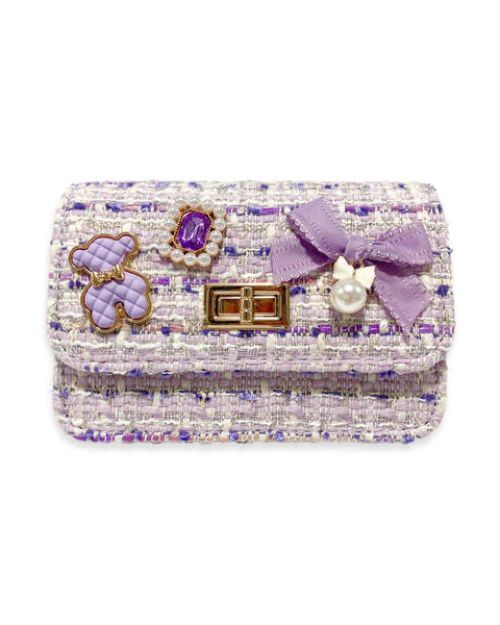 Purple tweed little girls purse with a quilted purple and gold bear charm, purple jewel with little pearls around charm, gold twist clasp, and a small purple bow with a pearl dangling off the middle of the bow on the front flap of the purse. 