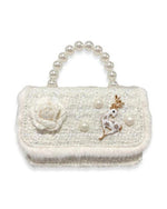 An image of a girl's ivory tweed purse with a large pearl handle, the front flap has white fur around the edge and a tweed ivory flower on the front, with 3 large pearls spaced out around an ivory and gold deer charm.  