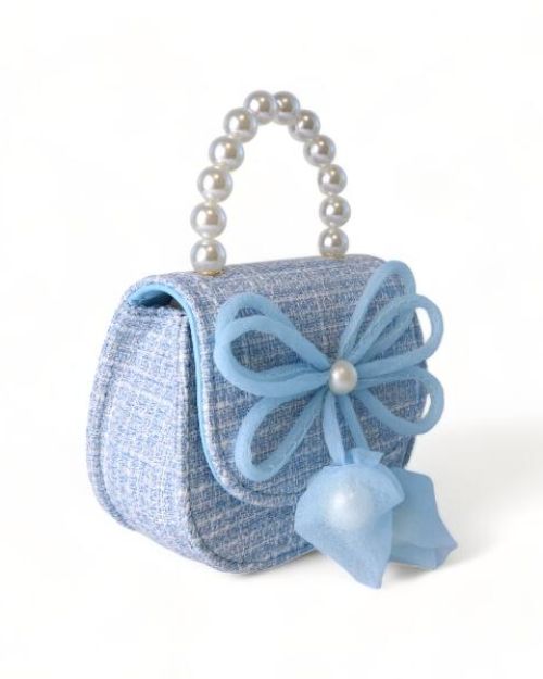 Side view of a little girls blue tweed pearl handle purse with a large blue thin string bow on the front with a pearl in the middle of the bow.