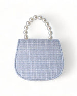 Back side of a little girls blue tweed pearl handle purse 