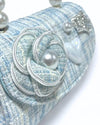 Up close image of a little girls blue tweed purse showing the detail of the tweed flower with pearl in the middle and heart pearl charm