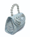 Side view of the little girls blue tweed pearl handle purse showing the detail of the tweed flower with pearl in the middle, pearl heart charm, large pearl charm, and a rhinestone crown
