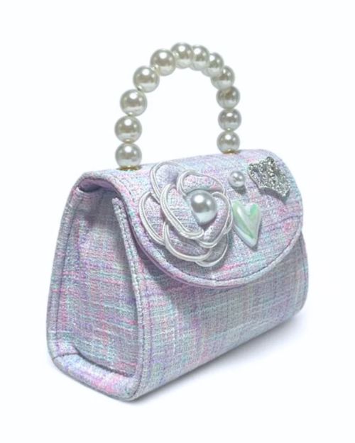 Side view of the little girls purple tweed pearl handle purse showing the detail of the tweed flower with pearl in the middle, pearl heart charm, large pearl charm, and a rhinestone crown