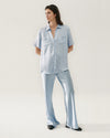 High-waisted, sky blue silk pants with a relaxed fit, draping gently over the legs. Pants are paired with matching top.