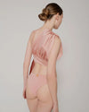 Burnette model showing the back of the 3 piece swimsuit in baby pink.