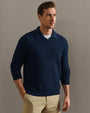 Person wearing a navy blue textured knit long-sleeve polo shirt paired with khaki trousers in a smart casual outfit.