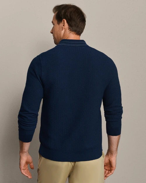 Back view of a navy blue textured knit long-sleeve polo shirt with ribbed hem and classic collar.
