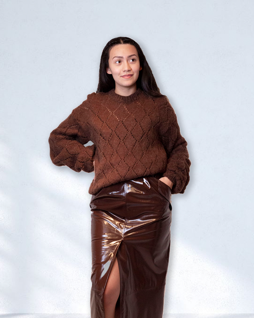 Brunette model wearing brown crochette sweater with diamond pattern.