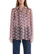 A woman wearing a burgundy and white patterned shirt, showcasing a stylish and contemporary design.
