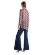 Back view of a woman in flared jeans and a blouse, showcasing a casual yet stylish outfit.
