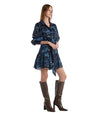 A woman showcases a blue dress paired with stylish boots.