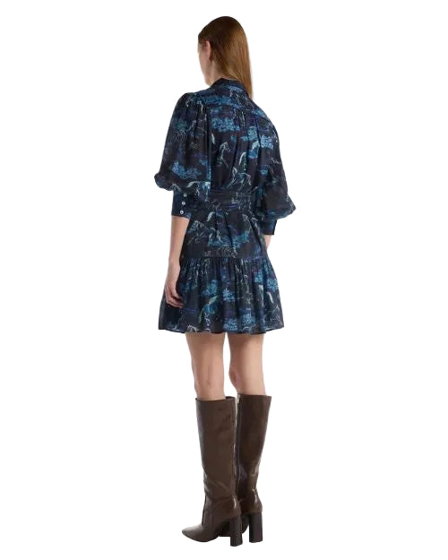 The back view of a woman wearing a dress and boots, highlighting her fashionable look and elegant silhouette.