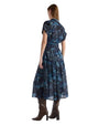 A woman in a blue floral and horse design dress is seen from the back, showcasing the dress's vibrant floral and horse pattern.