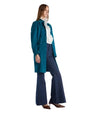 A woman in a luxurious blue suede coat paired with wide flared jeans, highlighting a chic and tailored look.