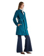  A woman in a blue suede coat and wide flared jeans, showcasing a sophisticated and timeless outerwear style.