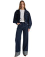 A denim jacket is styled with a white shirt and blue jeans, creating a casual and trendy outfit.