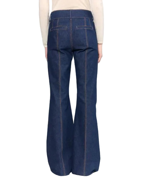 Back view of a woman wearing blue denim pants, showcasing the fit and style of the jeans.