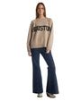 A woman wearing a sweater that features the word "Houston" prominently displayed on the front.