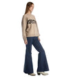 A woman models a sweater with "Houston" written across the chest, showcasing a casual style.