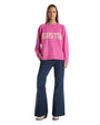 A woman in a pink sweater featuring the word "Houston" prominently displayed on the front.
