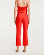 Back view of a red satin top and matching cropped pants with nude heels.