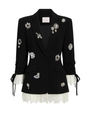 A black embellished blazer with white lace-trim on a plain background.
