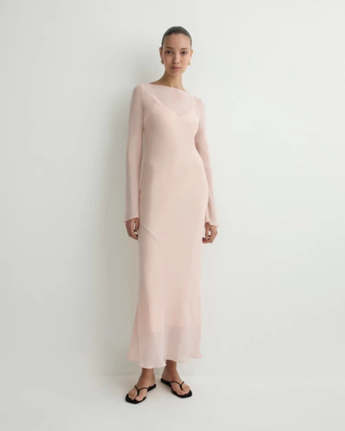 Blush pink sheer long-sleeve maxi dress with a fitted silhouette and flowing hem