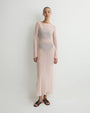 Blush pink sheer long-sleeve maxi dress with a semi-transparent design and fitted silhouette
