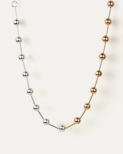 A close-up of a necklace with a combination of silver and gold chains, highlighting its sophisticated look.