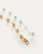 A stylish necklace made of gold and silver, complete with a functional clasp for easy fastening.