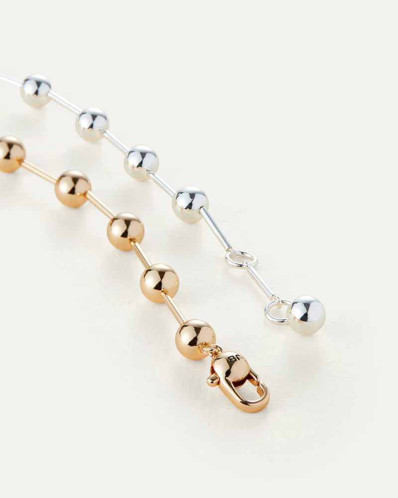 A stylish necklace made of gold and silver, complete with a functional clasp for easy fastening.