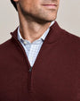 Close-up of a men's burgundy mock neck quarter-zip knit sweater with ribbed texture and zipper placket