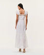 Back view of a white lace-trim maxi dress featuring a square open back, flutter sleeves, fitted waist, and flowing tiered skirt.