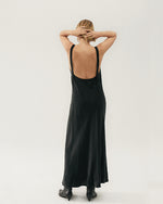 Back view. Slip black dress on model in black.