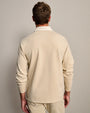 Back view of a men's beige long-sleeve polo shirt with ribbed cuffs and classic collar.