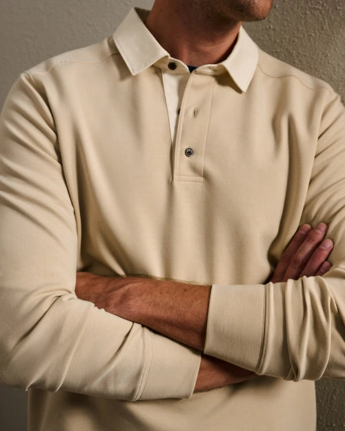Close-up of a men's beige long-sleeve polo shirt featuring a classic collar, three-button placket, and ribbed cuffs.