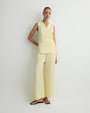 Light yellow sleeveless wrap top and wide-leg cropped pants set with black flip-flops