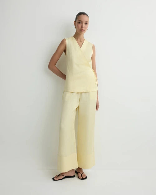 Light yellow sleeveless wrap top and wide-leg cropped pants set with black flip-flops