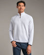 Person wearing a white textured quarter-zip performance pullover with long sleeves and navy pants against a neutral studio background.