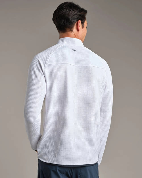 Back view of a white textured performance quarter-zip pullover with long sleeves, worn with navy pants against a neutral studio background.