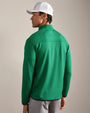 Back view of a green textured quarter-zip performance pullover with long sleeves, mock neck collar, and athletic fit, paired with light gray pants and a white golf cap.