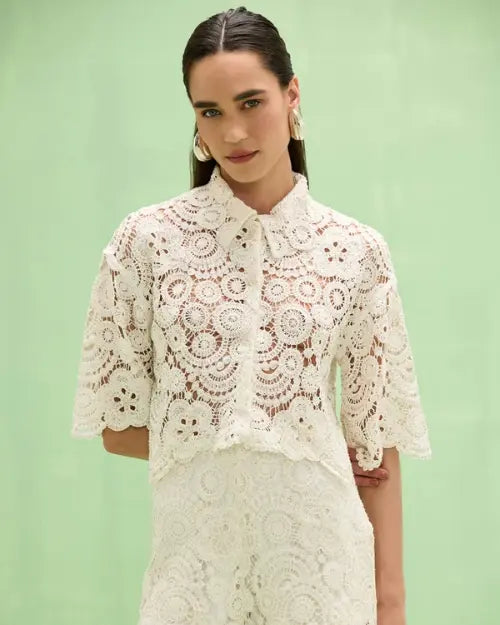 Women's white crochet lace blouse with floral pattern, tie-neck collar, elbow-length sleeves, and coordinating lace shorts.