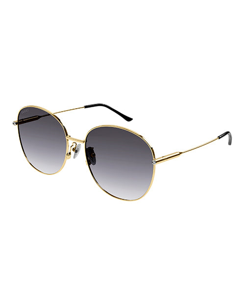 A pair of round-framed sunglasses with a thin gold metal frame with grey lenses. The sunglasses have black earpieces.