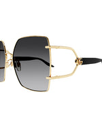 Side view of Rectangular oversized Gucci sunglasses. The temples are black, and the large lenses appear to be a gradient black with GG logo and gold rim. 